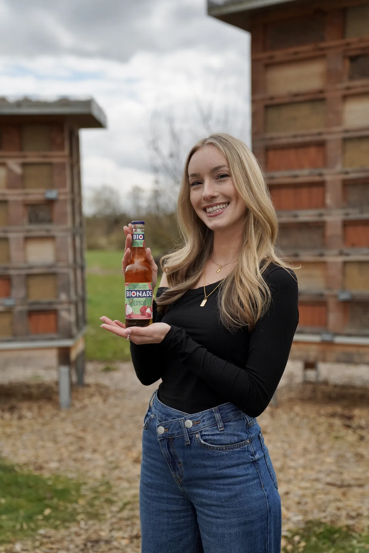 Elena Hirle mit der Litschi-Flasche vor Insektenhotels.
